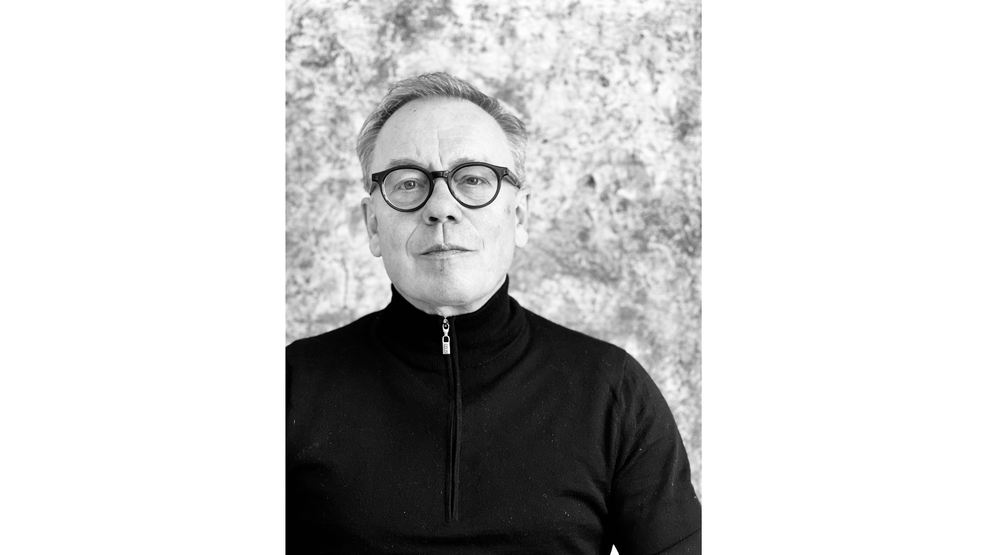 Das Foto zeigt ein Protrait von Søren Nielsen vor einem hellen Hintergrund